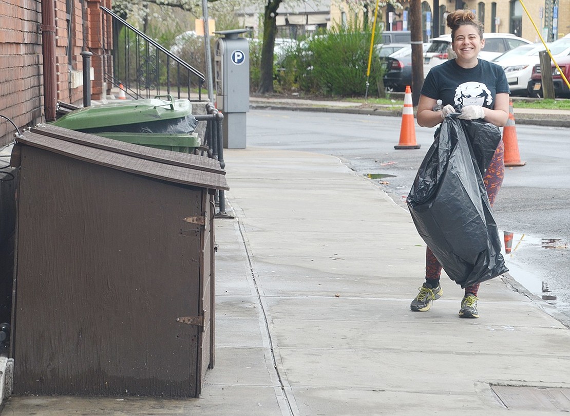 In the drizzling rain, Stamford, Conn. resident Stefanie May gleefully clutches a large black garbage bag as she searches for trash on Broad Street. The Capitol Theatre marketing director organized an Earth Day Clean-Up on Saturday, Apr. 20, to encourage venue staff and fans to help give back to the community.