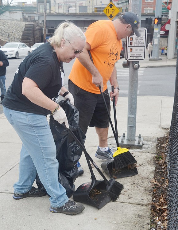 Sue and Dave Harmon sweep out dead leaves from a trench by the parking lot at the corner of Westchester Avenue and New Broad Street before moving on to the pavement itself. The Pleasantville couple are volunteering with around five other Squirrel Squad members, the Capitol Theatre’s street-promotions team.