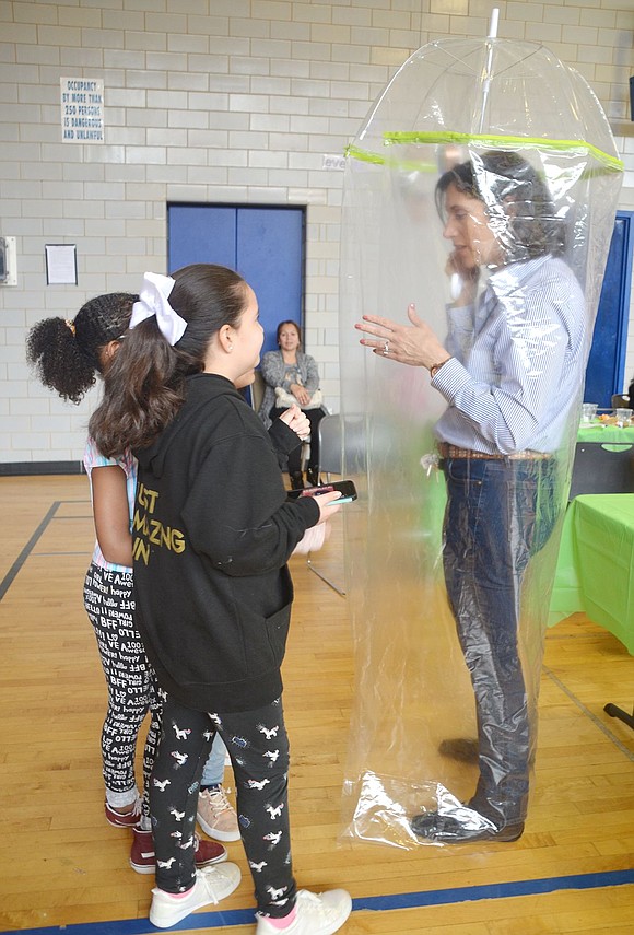 Three Edison School fourth-graders won a second-place award for their full-body umbrella with a blue tooth speaker installed. Carver Center Director of Talent Management Gina Nocco hops inside to check it out while Kamila Jimenez stands with her friends Jaylee Ephraim and Allyson Sanchez and puts on some music.