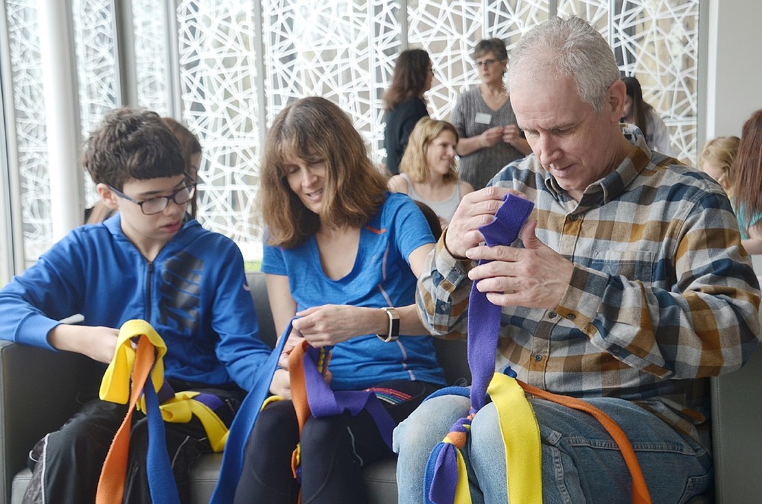 Rye resident Brian Hafford, his wife Wendy and their 13-year-old son Ayden focus closely on wrapping strips of felt together to make dog toys for service dogs. The family associated with Community Synagogue of Rye spent the afternoon repairing the world with various good deeds during Mitzvah Day on Saturday, May 4.