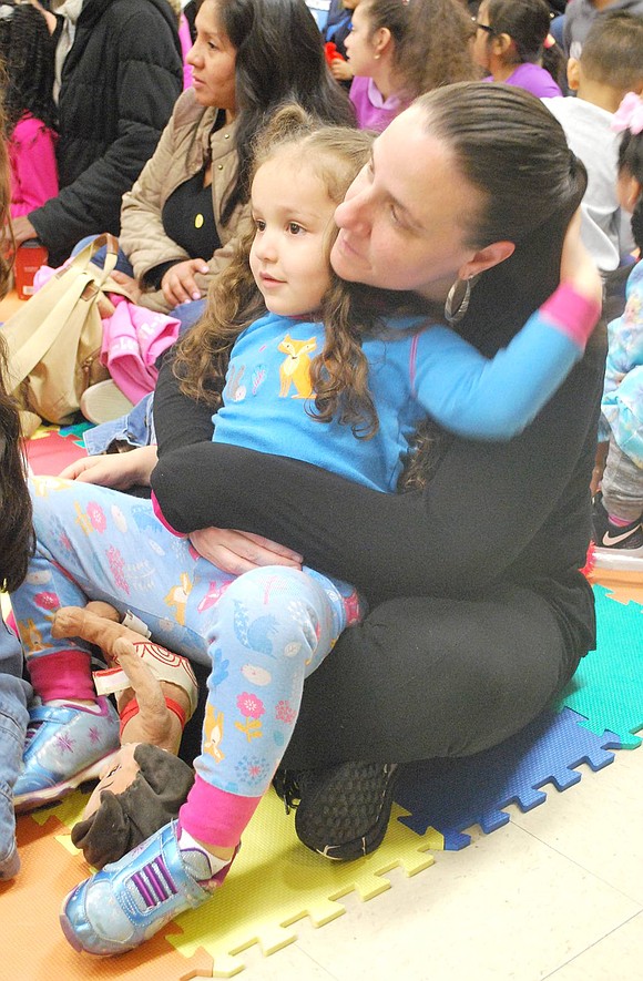 Haines Boulevard resident Kelly Castro gives her 3-year-old daughter Sophia sweet cuddles as they sit on the floor and listen to bedtime stories together.