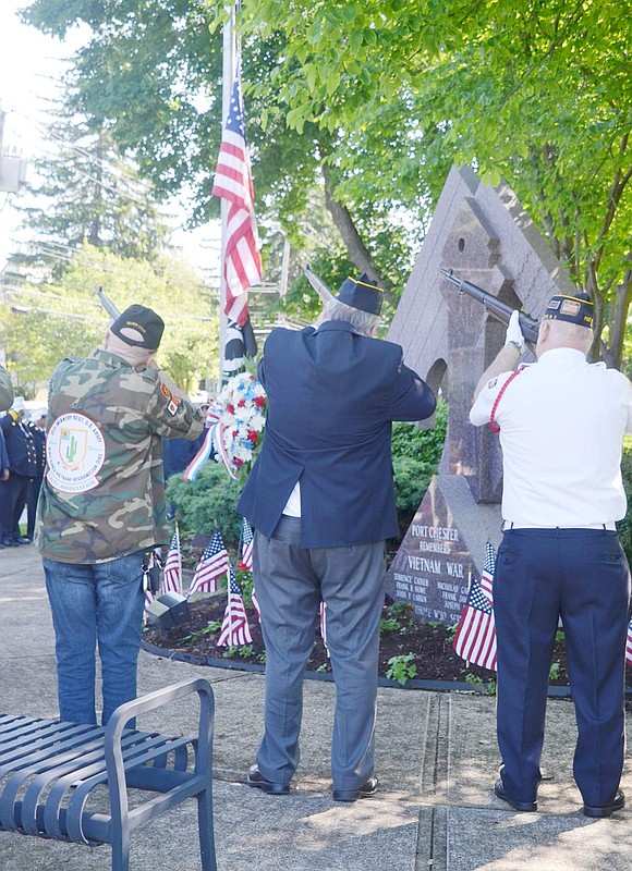 The American Legion Post 93 Firing Team, this year filled out with other local veterans, fires off symbolic shots during the brief early morning ceremony at the Vietnam War Memorial in Lyon Park.