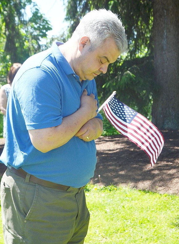 Port Chester Board of Education member Lou Russo bows his head during Taps at the Korean War memorial.