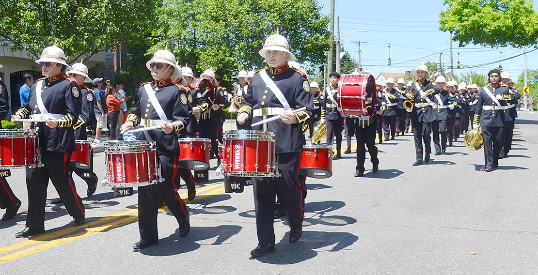 The Pride of Port Chester follows their drumline as they uniformly charge down Westchester Avenue in the parade following ceremonies at the war memorials around the villages.