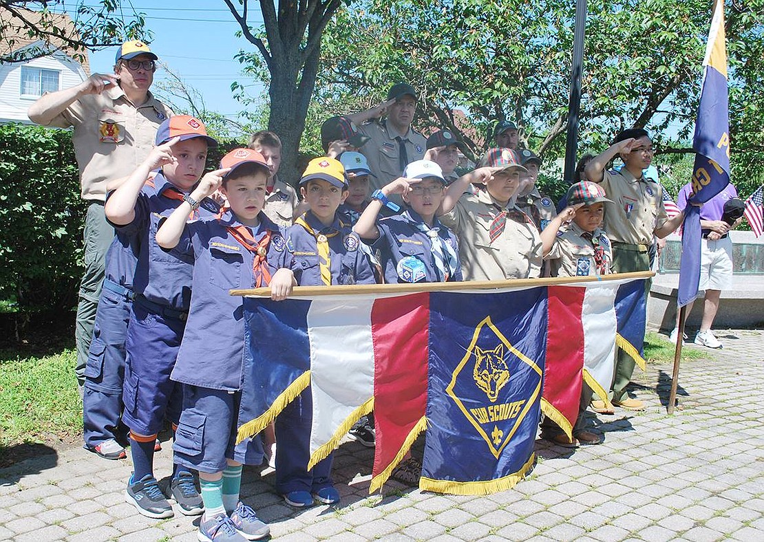 Members of different Port Chester/Rye Brook Cub Scout troops salute as high schoolers from Boy Scout Troop 400 do the raising of the flags during the ceremony at Veterans’ Memorial Park.