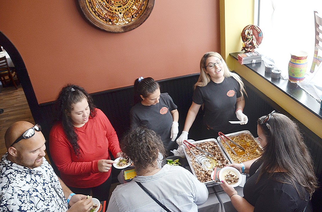 Hungry for tacos? Salsa Picante visitors gather around employees Isabela Ordonez (right) and Yoharly Guerrero to try their choice of chicken or pork tacos. The 110 Adee St. restaurant is one of 22 that more than 300 people visited during the annual Taste of Port Chester on Sunday, June 2—raising an estimated $9,000 for the Tamarack Tower Foundation, which gifts grants and scholarships to the Port Chester School District.