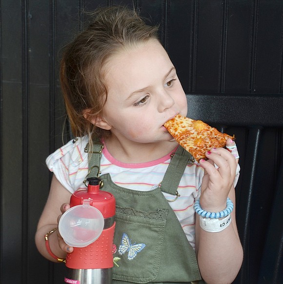 After climbing into a tall chair at the Colony Grill at 35 Abendroth Ave., 4-year-old Greenwich resident Lily Schacter settles in to munch on a slice of cheese pizza.