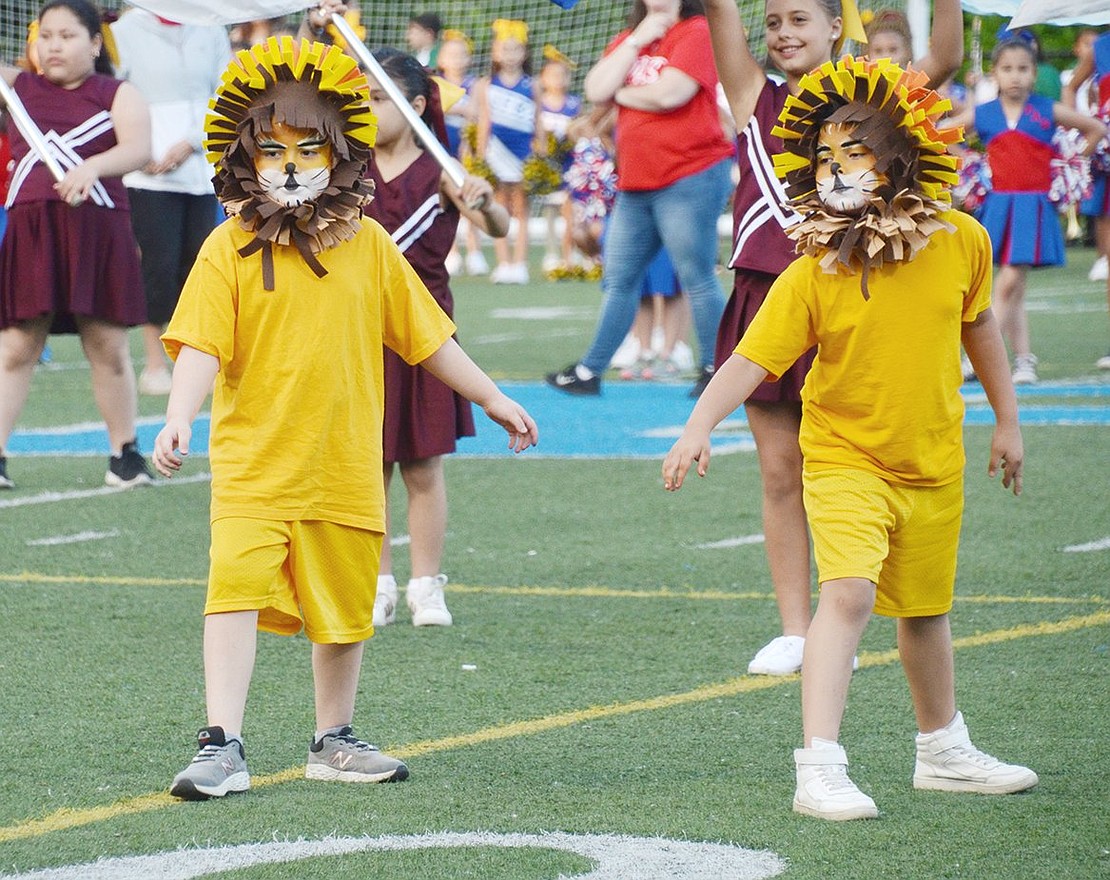 Surf’s up! As the King Street School spirit team does their routine to the song “Wipe Out,” they surround third-graders Dominick Becerra (left) and Emanuel Gonzalez who pretend to be surfing as the lion mascots.