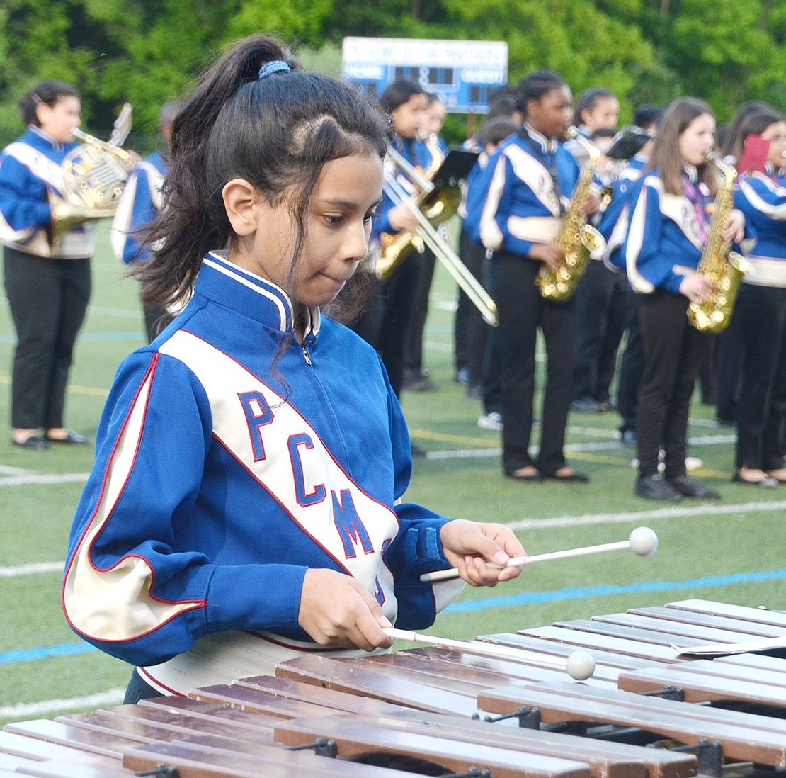 Port Chester Middle School sixth-grader Elizabeth Magana bites her lip as she plays the marimba on the sidelines.