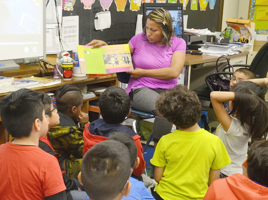 To teach children about famous Mexican figures, Lluvia Mendez, a class mom in Adriana DiGiacomo’s second-grade dual language class, reads students a kids’ book about artist Frida Kahlo. Parents were invited to visit classrooms during Global Citizen Day to share customs and facts about their personal heritage.  