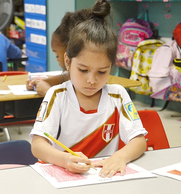 Decked out in her Peru sports jersey, Zoey Chavez, a kindergartener in Jessica DiGiorgi’s class, takes her Peruvian flag drawing seriously.