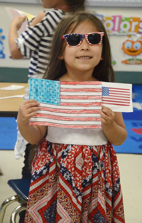 With a red, white and blue dress along with matching sunglasses, kindergartener Arianna Chuco came to school to represent the U.S.A. She holds up her drawing of the American flag that she made in Jessica DiGiorgi’s class.