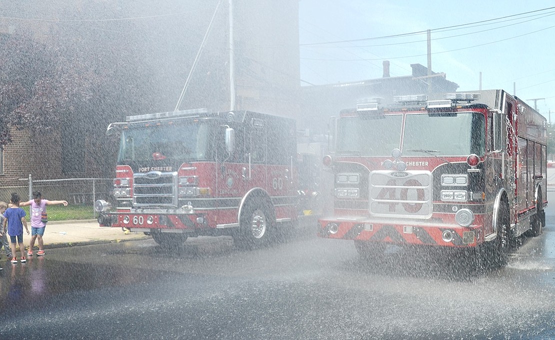 Water blasted from the top of an old Port Chester Fire Department fire truck to shower the department’s two new rigs.