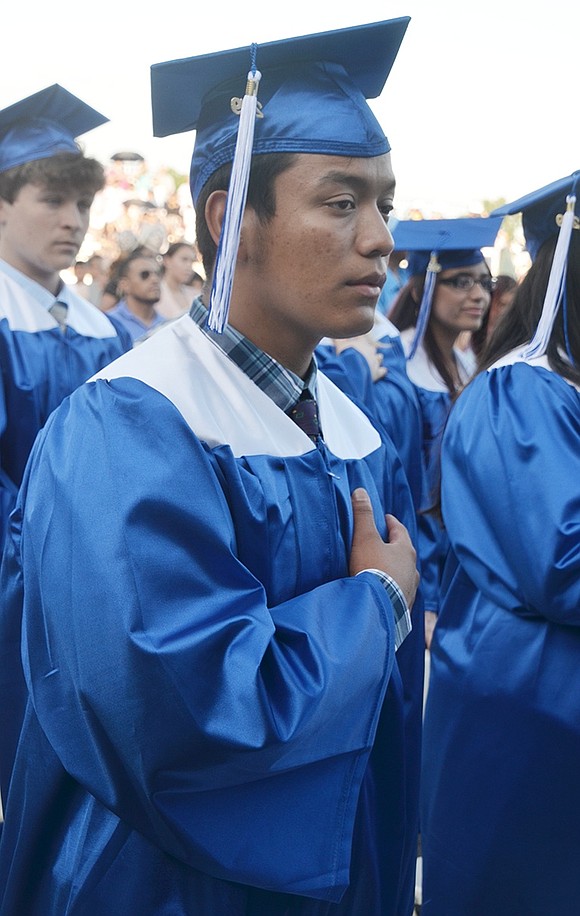 As senior singers sing the national anthem, Erick Nepthaly Gonzalez Zeldeda pensively places his hand on his heart.