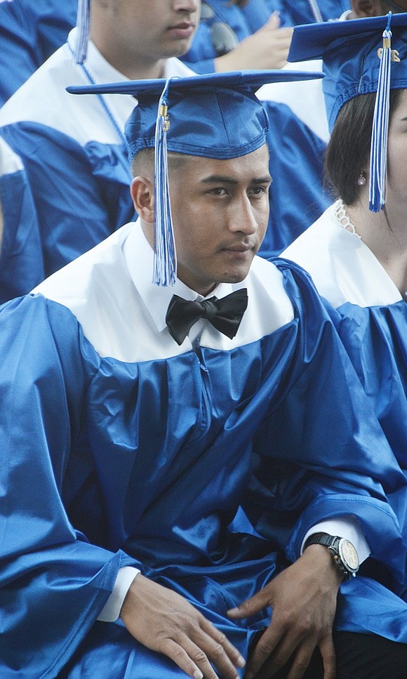 Osmar Cruz Figueroa listens to speakers during the graduation ceremony.