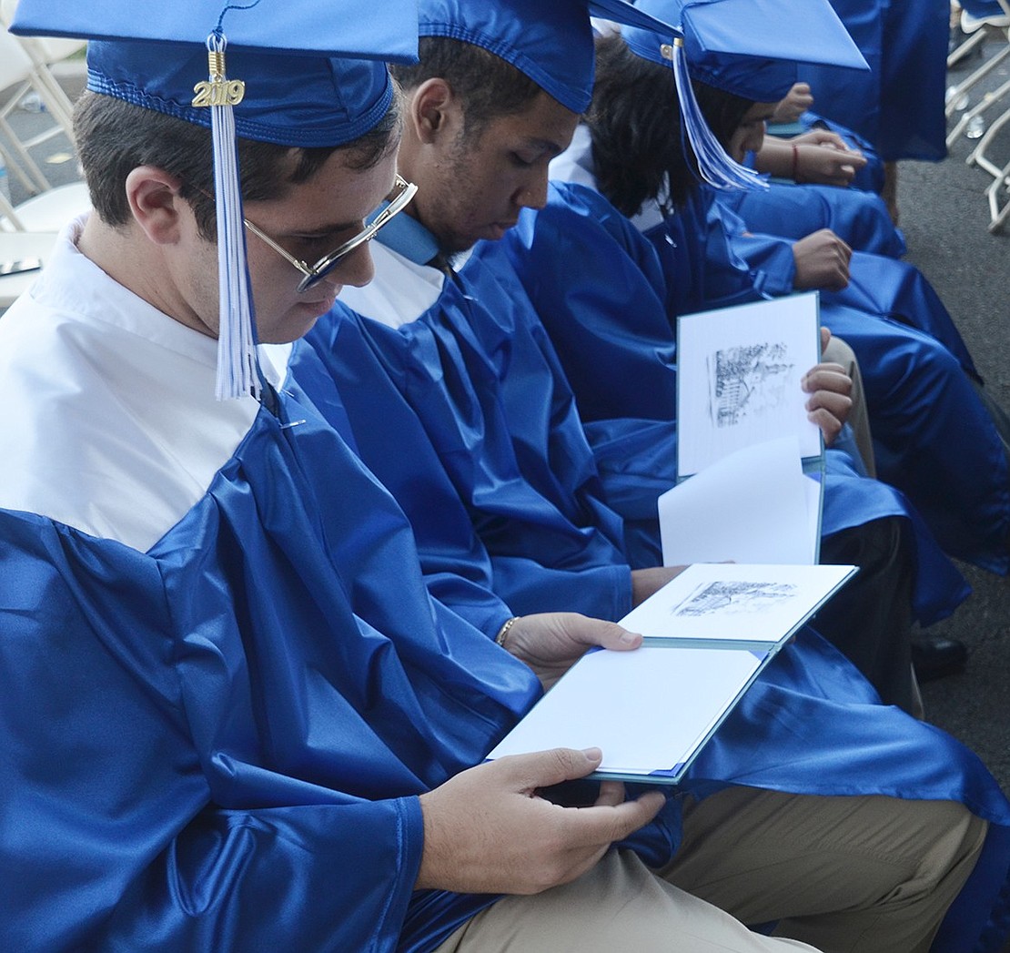 After walking across the stage, down the grand staircase and sitting back in his seat, Stephen Carroll peeks inside his diploma case.