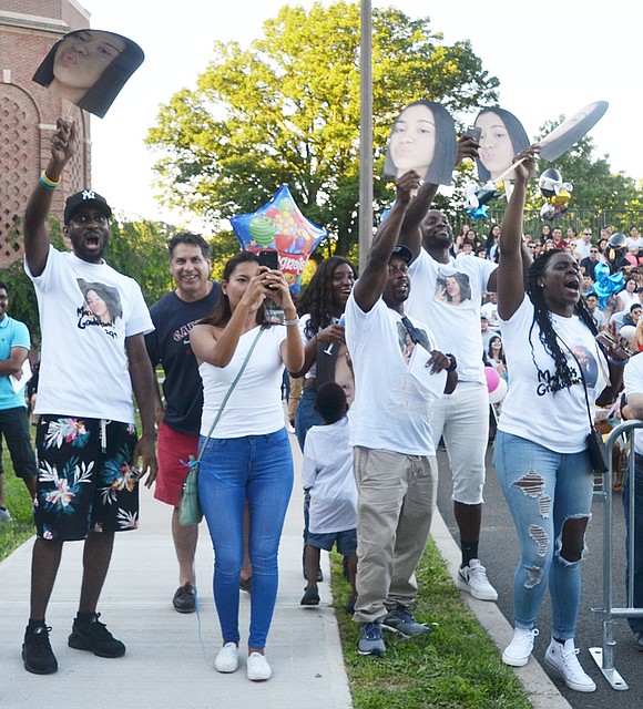 When Marian Lucas’s name is called, her family and friends go wild while wearing shirts and waving masks featuring her face.