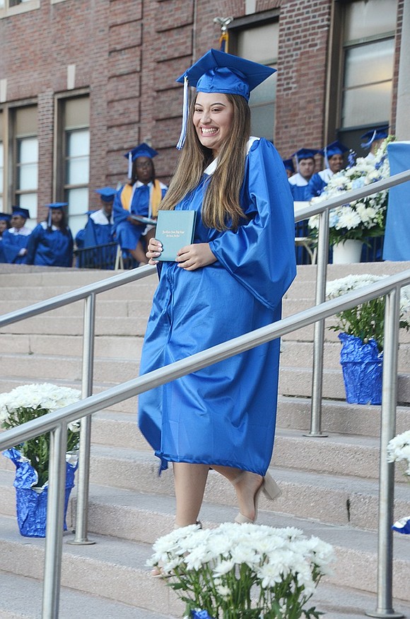 Olivia Perrone giggles with delight as she clutches her freshly earned diploma and walks back to her seat.