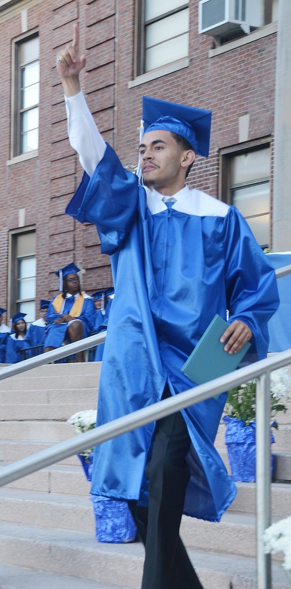 After receiving his diploma, José Rodriguez shoots his finger in the air as he marches down the high school grand staircase and onward into the future during the Port Chester High School commencement ceremony on Thursday, June 27. 