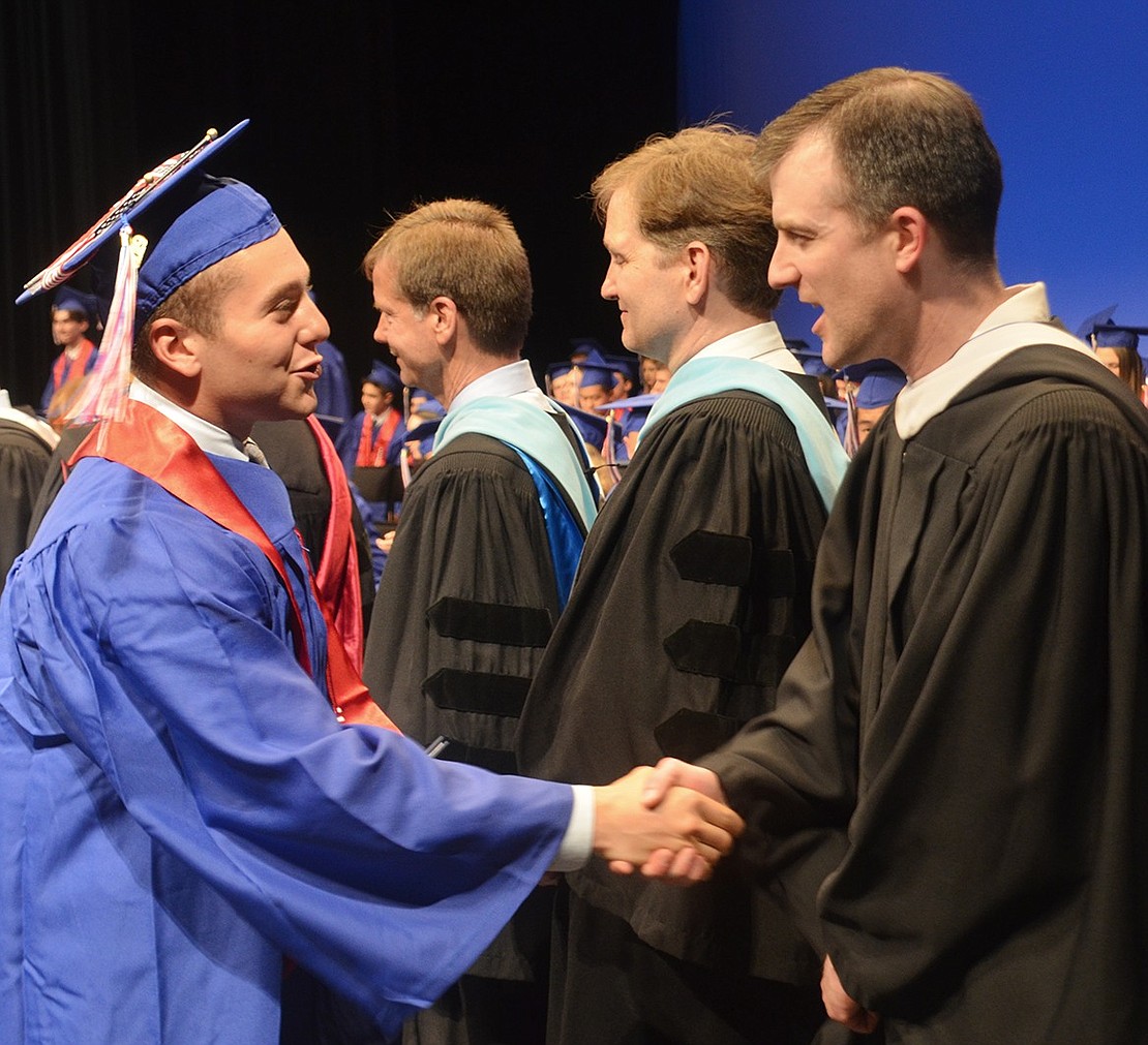 After four years of high school and a short walk across the Purchase College Performing Arts Center stage, Gabriel Landau obtains his diploma and shakes Blind Brook High School Principal Derek Schuelein’s hand during the Class of 2019 graduation ceremony on Tuesday, June 25.