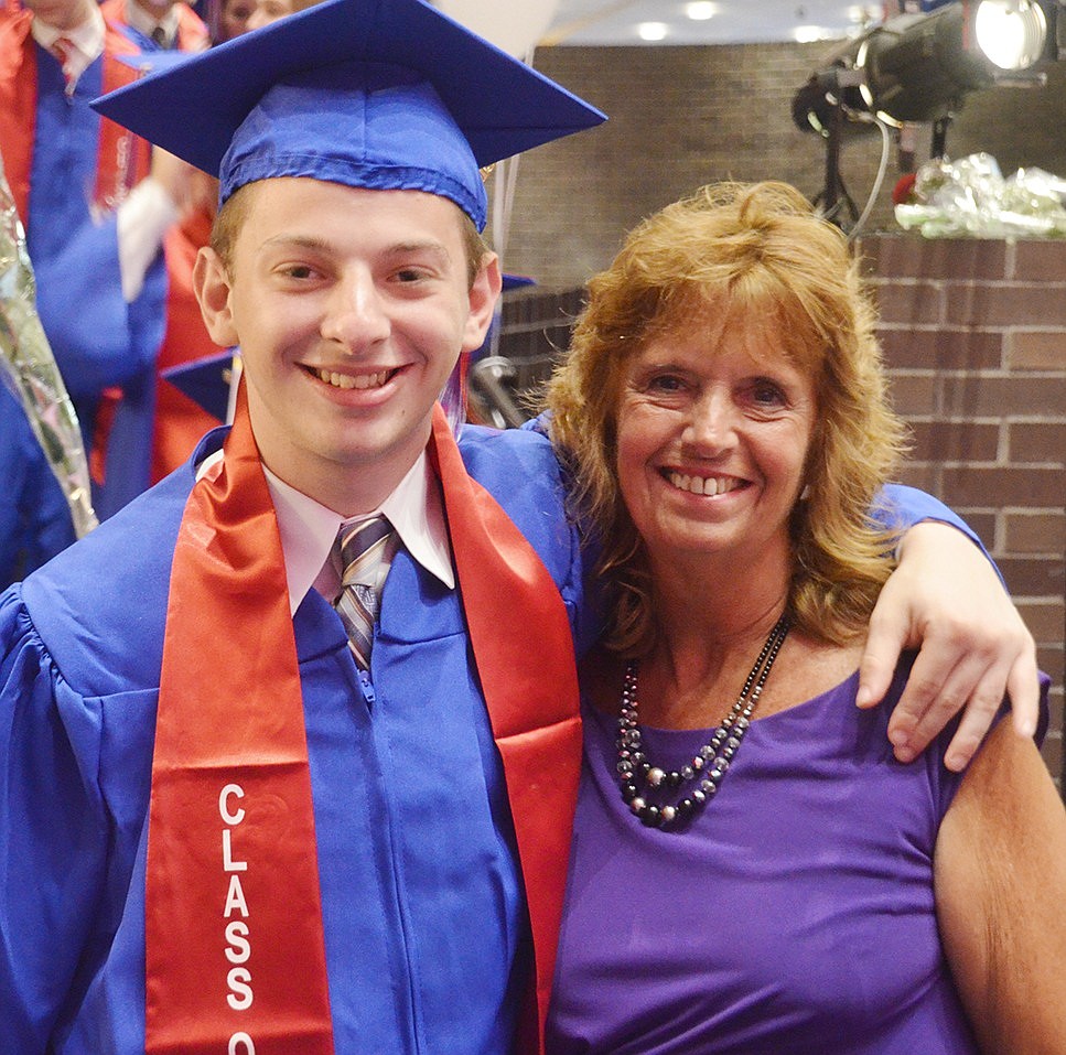 Before making his grand entrance, Thomas Chason puts his arm around writing center teacher Rita Gianfrancesco to pose for a photo.