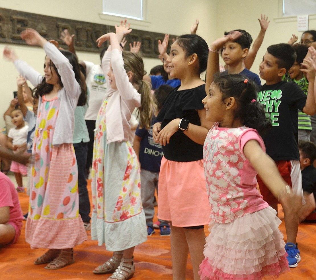 Children dance along to the “Chicken Dance” after learning about Feathers the Silkie chicken.