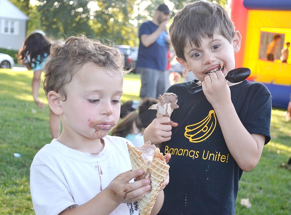 After digging into their ice cream cones, 4-year-old Caleb Fery (left) and 5-year-old John Gasparini have sufficiently given themselves chocolate mustaches. The Rye Brook children are visiting Pine Ridge Park with their families on Friday, July 12, for Ice Cream Friday, a Village-sponsored event that provides free sweet treats for the community from 6 p.m. to 7:30 p.m. every Friday in July.