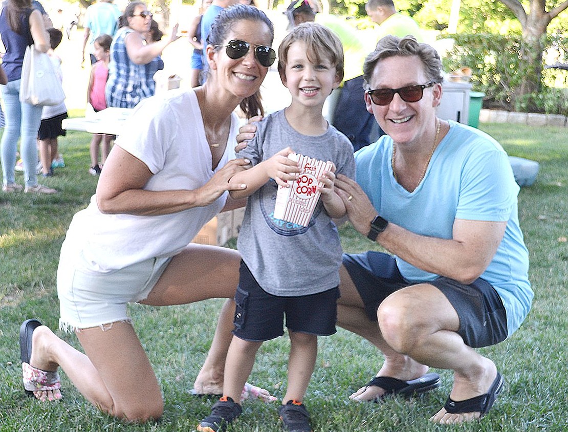 Ice cream isn’t the only summertime treat to enjoy at the park. Pine Ridge Road residents Alyson and Michael Leon enjoy a box of popcorn with their 4-year-old son, Aiden.