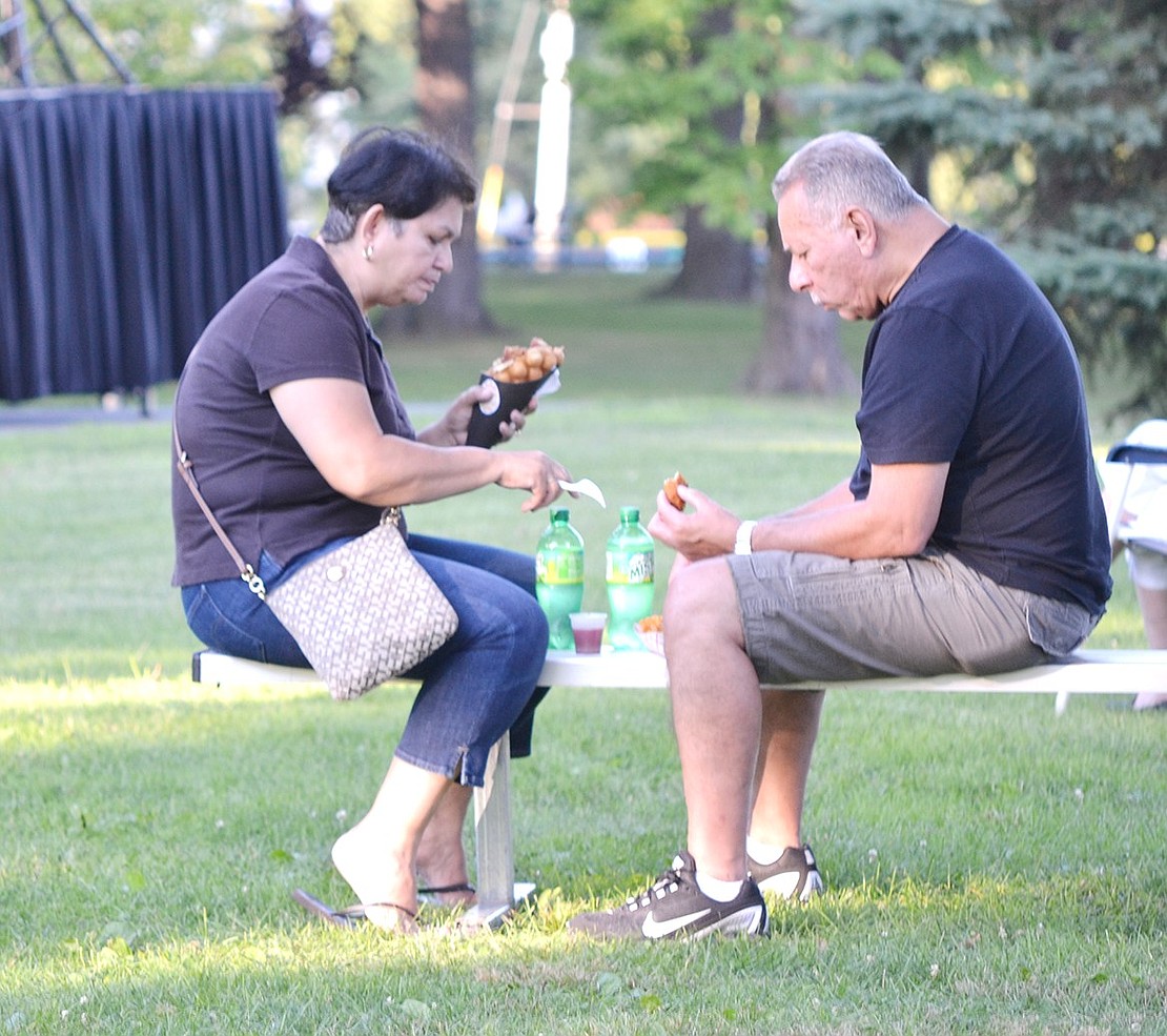 After driving into town from Larchmont, Ann and Ralph Cosme enjoy their night at Lyon Park by sharing a dinner from the Waffle Box food truck.