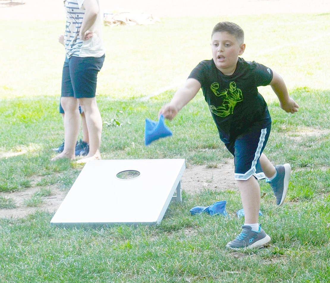 Joey Vasile, 8, perfects his Cornhole form as he tosses a blue bean bag toward a board roughly 15 feet away. The Stamford, Conn. resident is visiting the picnic with his father Joe, who works for the Village of Rye Brook.