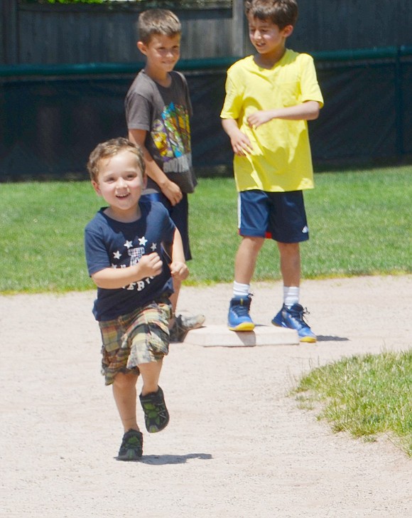 Crossway resident Caleb Fery, 4, bolts for third base after his kickball teammate smashes the ball into the outfield.