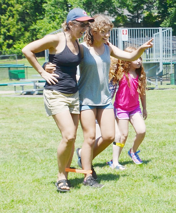 Eleven-year-old Loch Lane resident Alexandra Maniscalco points to the finish line as she hops along with her mother Michelle during the three-legged race.