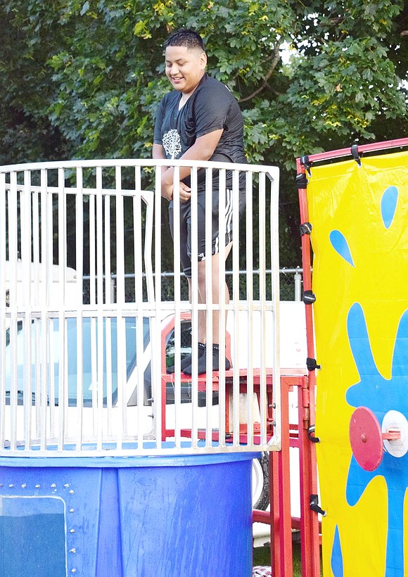 Dripping wet after getting drenched in the dunk tank, 14-year-old Brian Collaguazo climbs back into position and nervously waits to inevitably fall into the water again. The Port Chester High School rising freshman is sacrificing his dryness as a volunteer at the carnival.