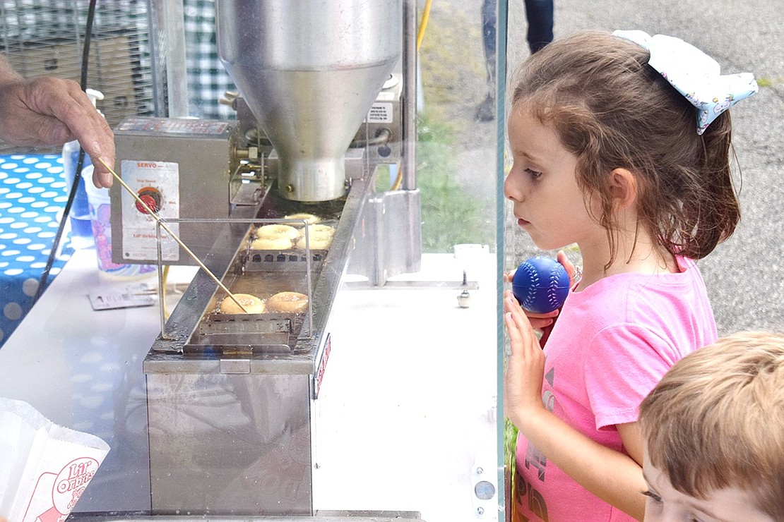 With her face pressed up to the glass, Violet Van der Wateren’s belly growls as she watches Brice Schmaling fry up mini donuts. Don’t worry, the King Street School rising second-grader got her own bag of cinnamon sugar BT Donuts shortly thereafter.