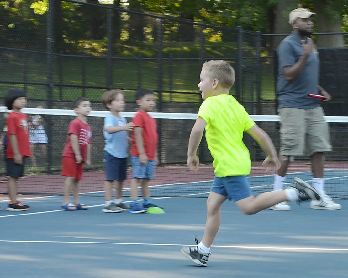 Possibly a future track star in the making, 5-year-old John Umbro sprints across the tennis courts ready to tag his teammate during a relay. 