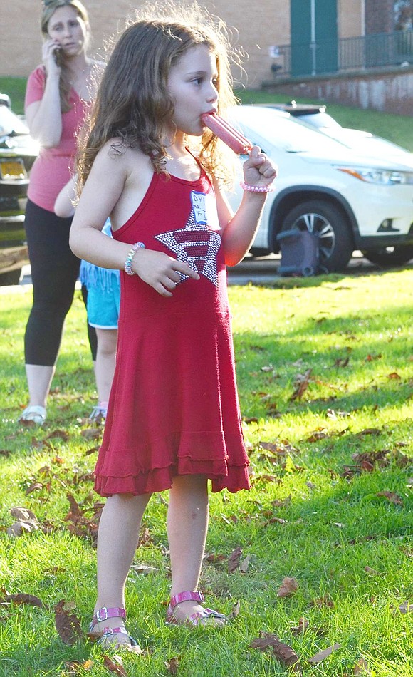 Dylan Brauntuch, a 4-year-old and rising kindergartner at Ridge Street School, enjoys an end of summer frozen dessert after playing games with her future classmates during the social. 