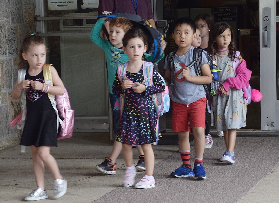 With their second day of school complete, some of the younger students exit out of the main entrance at Ridge Street Elementary School and wait to be picked up on Tuesday, Sept. 10. 