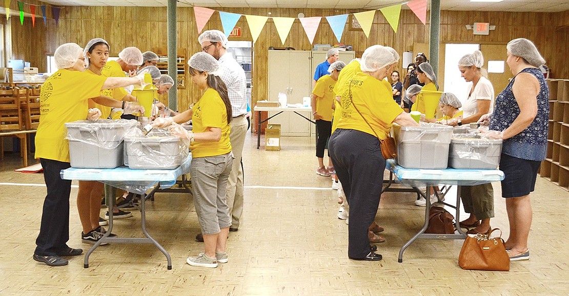 Volunteers work in assembly line fashion as they create a rice and bean meal package for Food 2 Grow On, a non-profit that aids needy children in the Port Chester Schools, and Hurricane Dorian victims. 