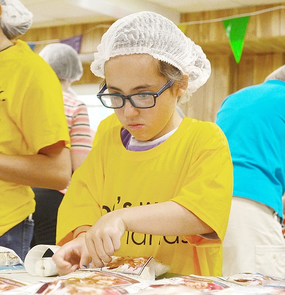 Park Avenue Elementary School fourth-grader Jamie Onofrio-Franceschini, 9, labels one of the packages before handing it off to be placed in a box.