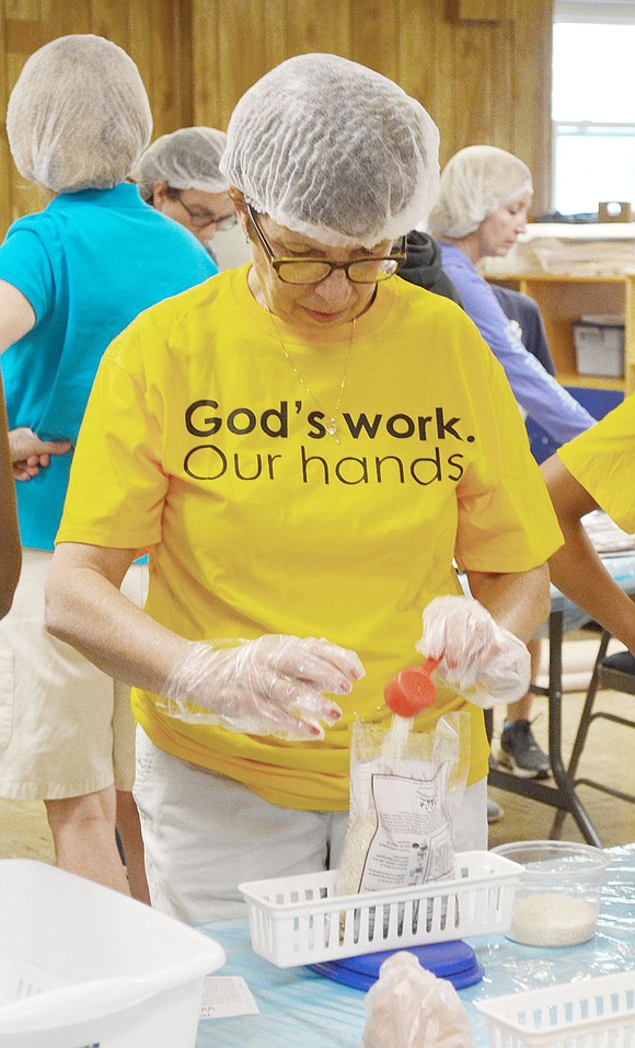 Pilgrim Drive volunteer Leslie Esposito fills one of the bags with extra rice so it will weigh between 388 and 390 grams.