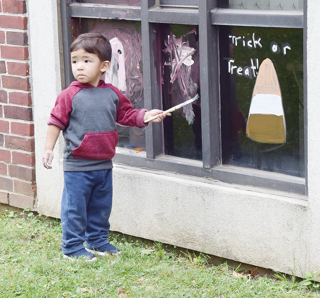 While brushing a window with deep-purple splotches, 2-year-old South Regent Street resident Jordan Rivera looks a little apprehensive.