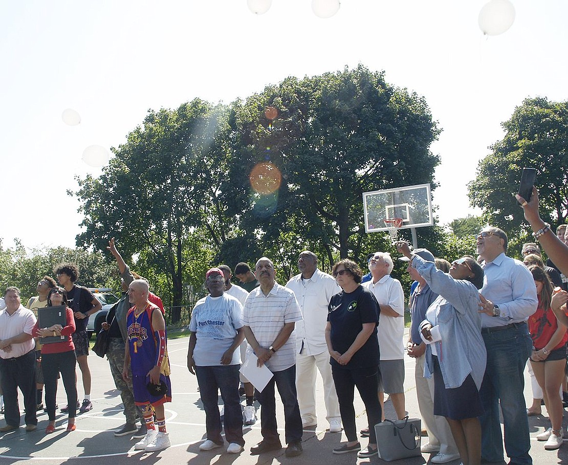 Unity Day participants release white balloons on the basketball courts of Columbus Park in memory of their loved ones who died recently.