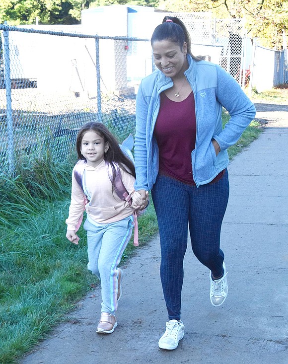 Coming from their home on King Street, first-grader Chelsea Pereira walks to school hand in hand with her mother Michelle.