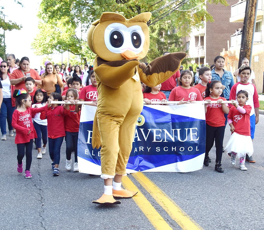 Followed by a sea of students demonstrating school pride in their red shirts, the Park Avenue School owl mascot (played by teacher’s assistant Marvin DeLeon) dances down Westchester Avenue on Sunday, Oct. 13, at the 113th Columbus Day Parade.