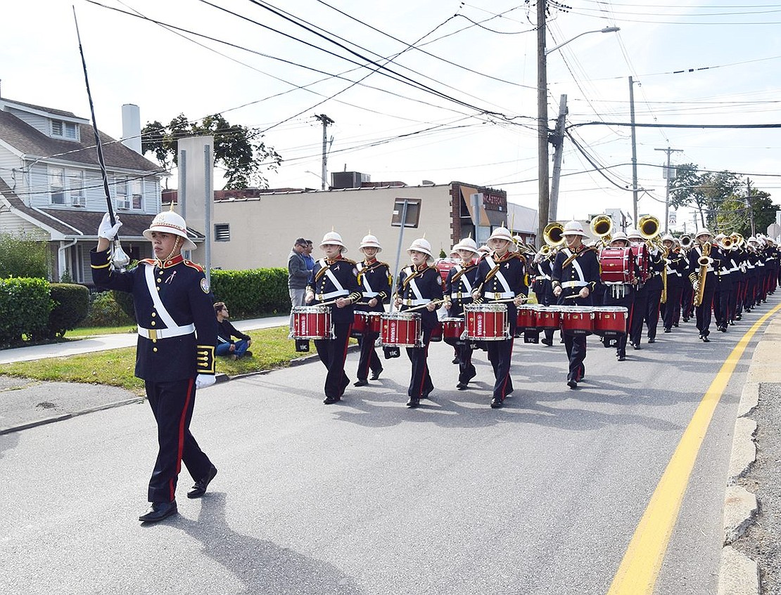 With his baton high in the air, Port Chester High School junior Brandon Molano leads the Pride of Port Chester down Westchester Avenue.