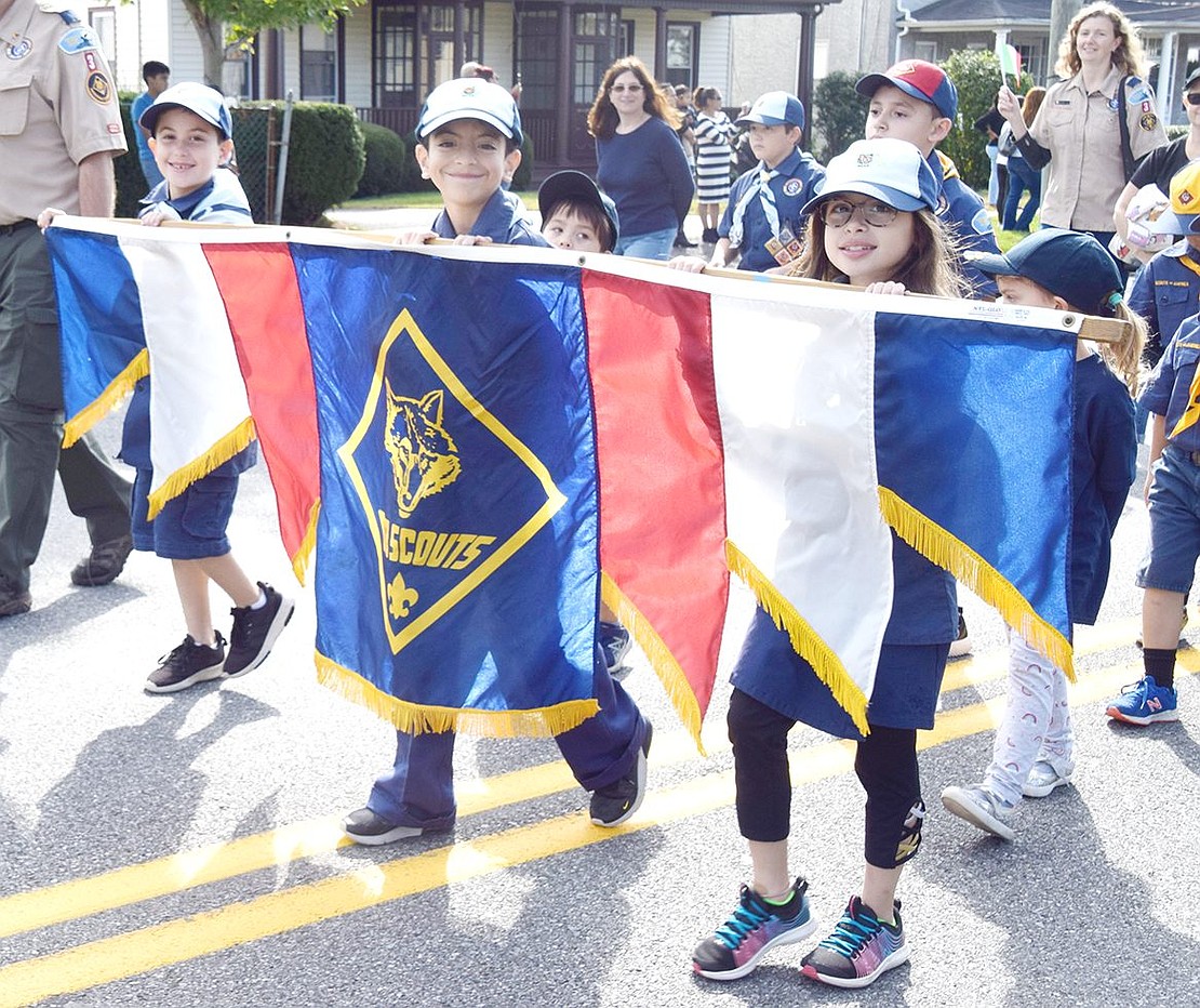 Representing Cub Scout Pack 3 of Rye Brook, Ridge Street School third-graders Matthew Geller (left), Hunter Genovese and Samantha Geller proudly march with the troop’s banner.