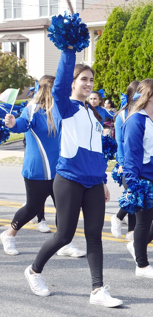 Marching with the Port Chester High School cheerleaders, sophomore Siena Russo waves her pom-pom at parade watchers sitting on the street curbs.