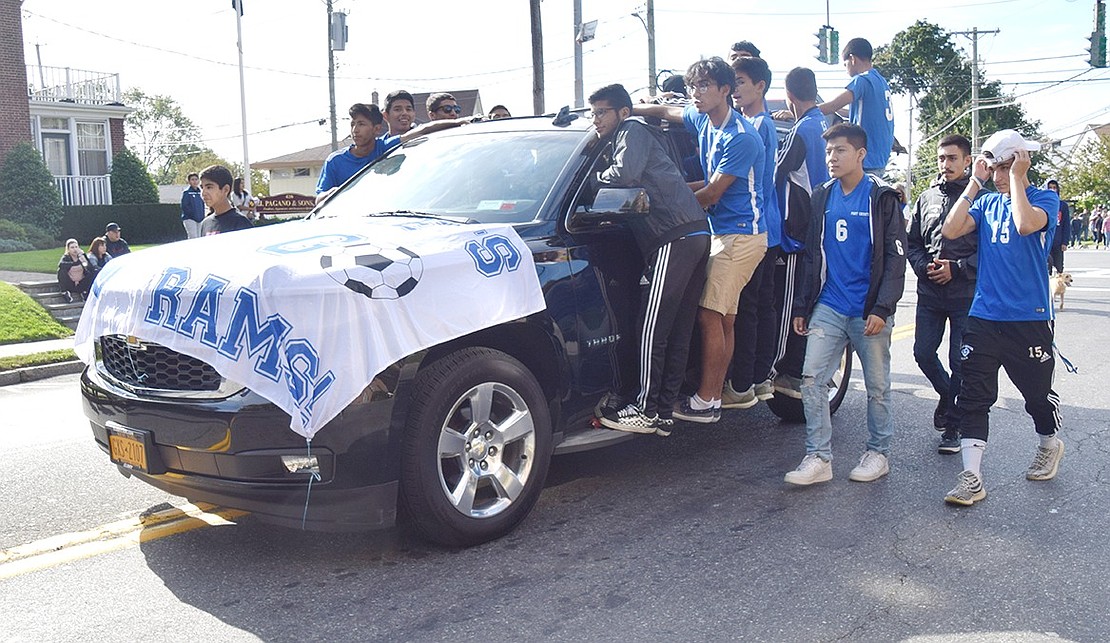 Right after passing the Westchester Avenue and Regent Street intersection, a dozen Port Chester High School athletes jump on a car representing the JV and Varsity boys’ soccer teams.