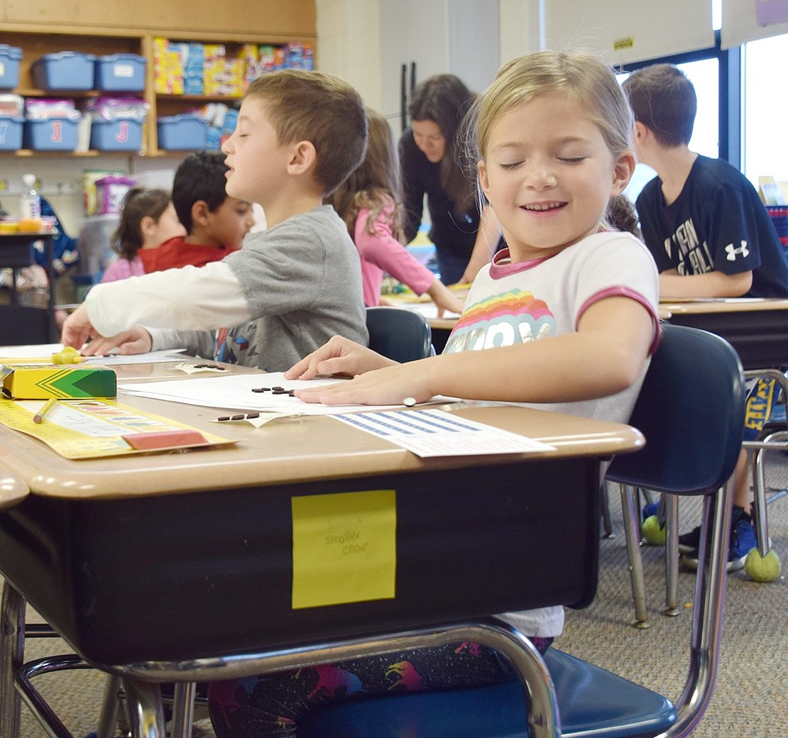 With closed eyes, first-grader Carly Katz runs her hand across a sheet of paper on which she spelled out her first name in braille using felt dots on Tuesday, Oct. 22. All grade levels at Bruno M. Ponterio Ridge Street School participated in activities during Creating Connections, a weeklong program that strives to teach students about inclusivity.