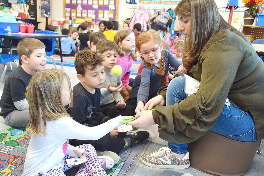 Creating Connections parent volunteer Stacy Sakellariou holds a braille ruler for students to feel in a kindergarten class at Ridge Street School.